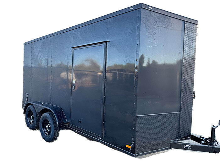 The image shows a black enclosed trailer parked on a surface with wheels visible at the front.
