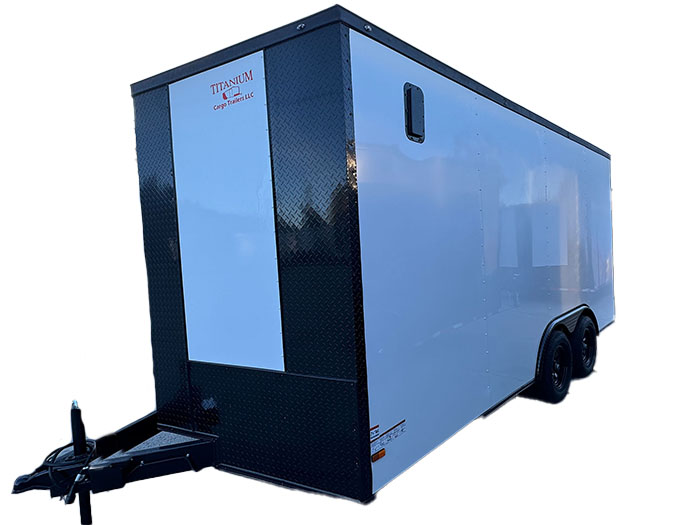 The image features a black and silver enclosed trailer with a white top and side panels, parked on a surface with an open sky background.