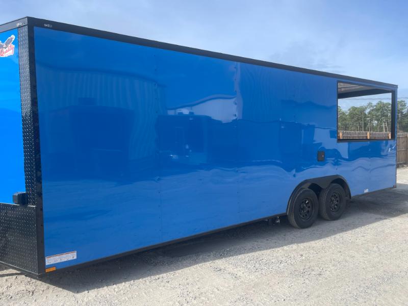 The image shows a large blue trailer parked on gravel, with an open side door revealing its interior.