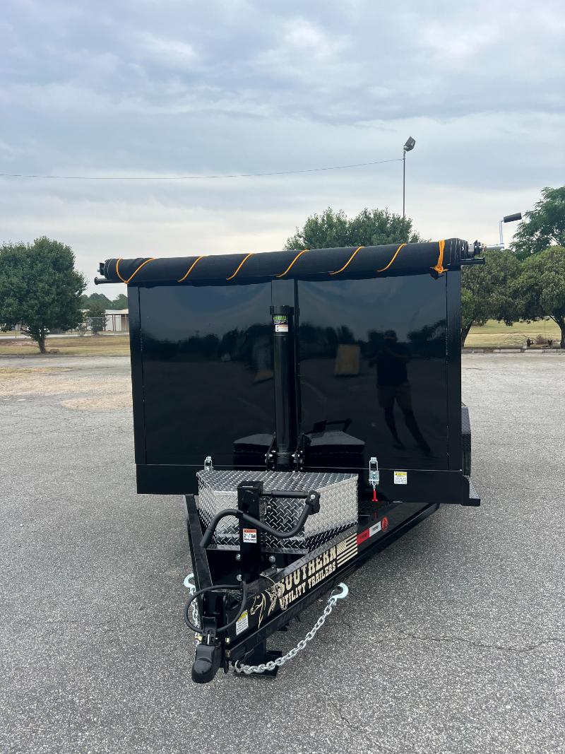 A black utility trailer with yellow stripes on its side parked in a parking lot.