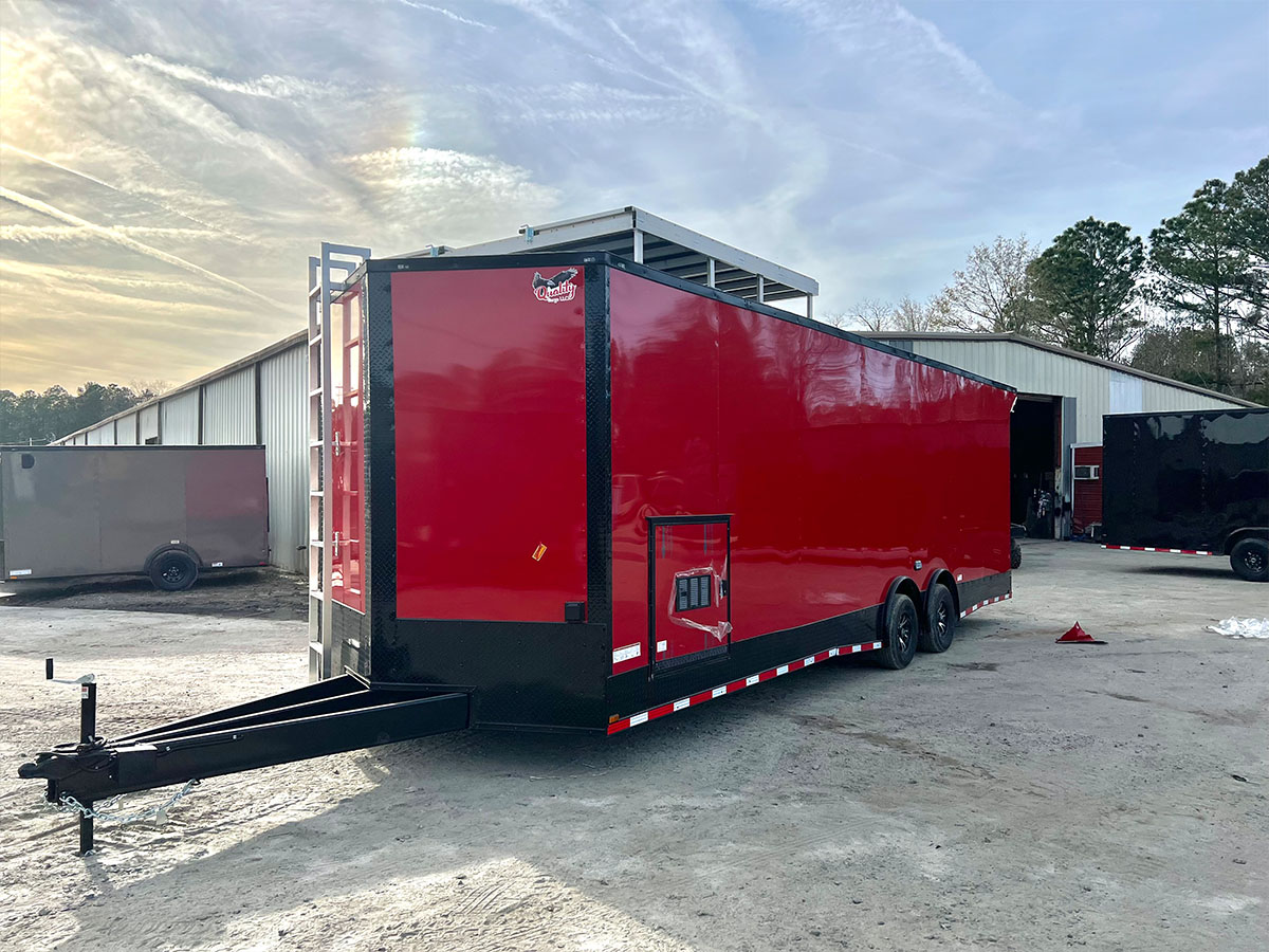 An image of a large red semi-truck parked inside a building with a clear sky visible through the windows.