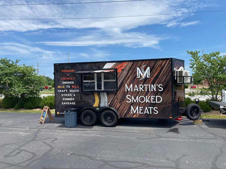 The image features a food truck parked outdoors with a sign displaying Martin s Smoked Meats on its side, indicating the type of cuisine served from this mobile establishment.