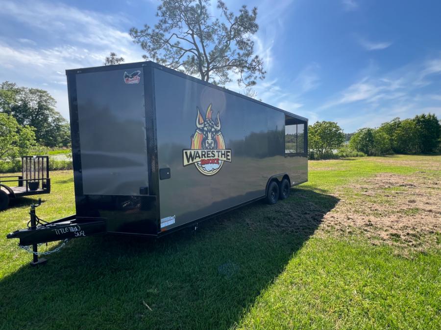 Alt-text Black trailer with Wake The Dead logo parked on grass.