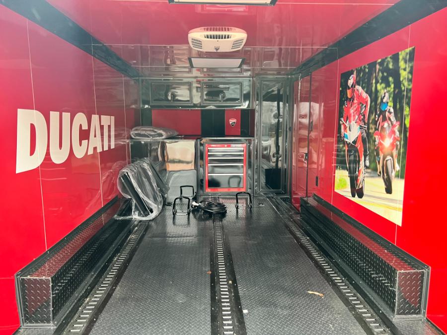 A Ducati-themed racing truck with racing gear and a sign for the brand.