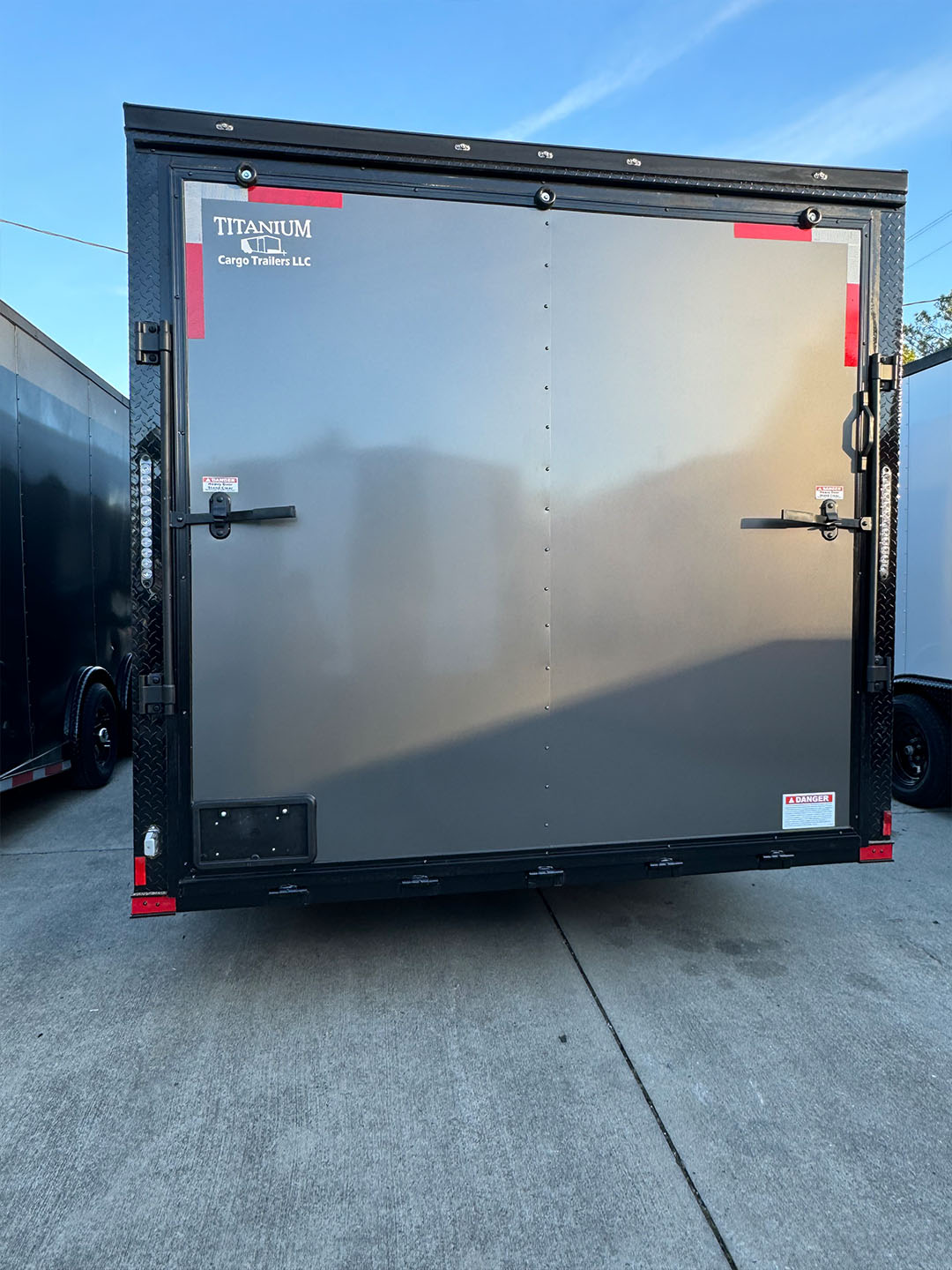 A black enclosed trailer parked on concrete.