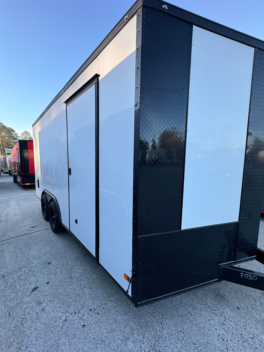 A large black enclosed trailer parked on an asphalt surface.