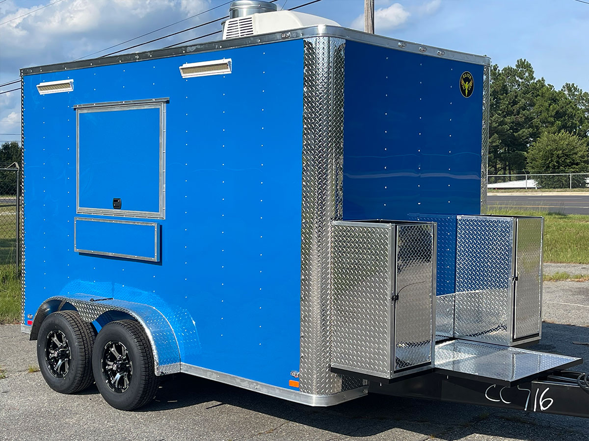 A blue and silver food truck parked on pavement.