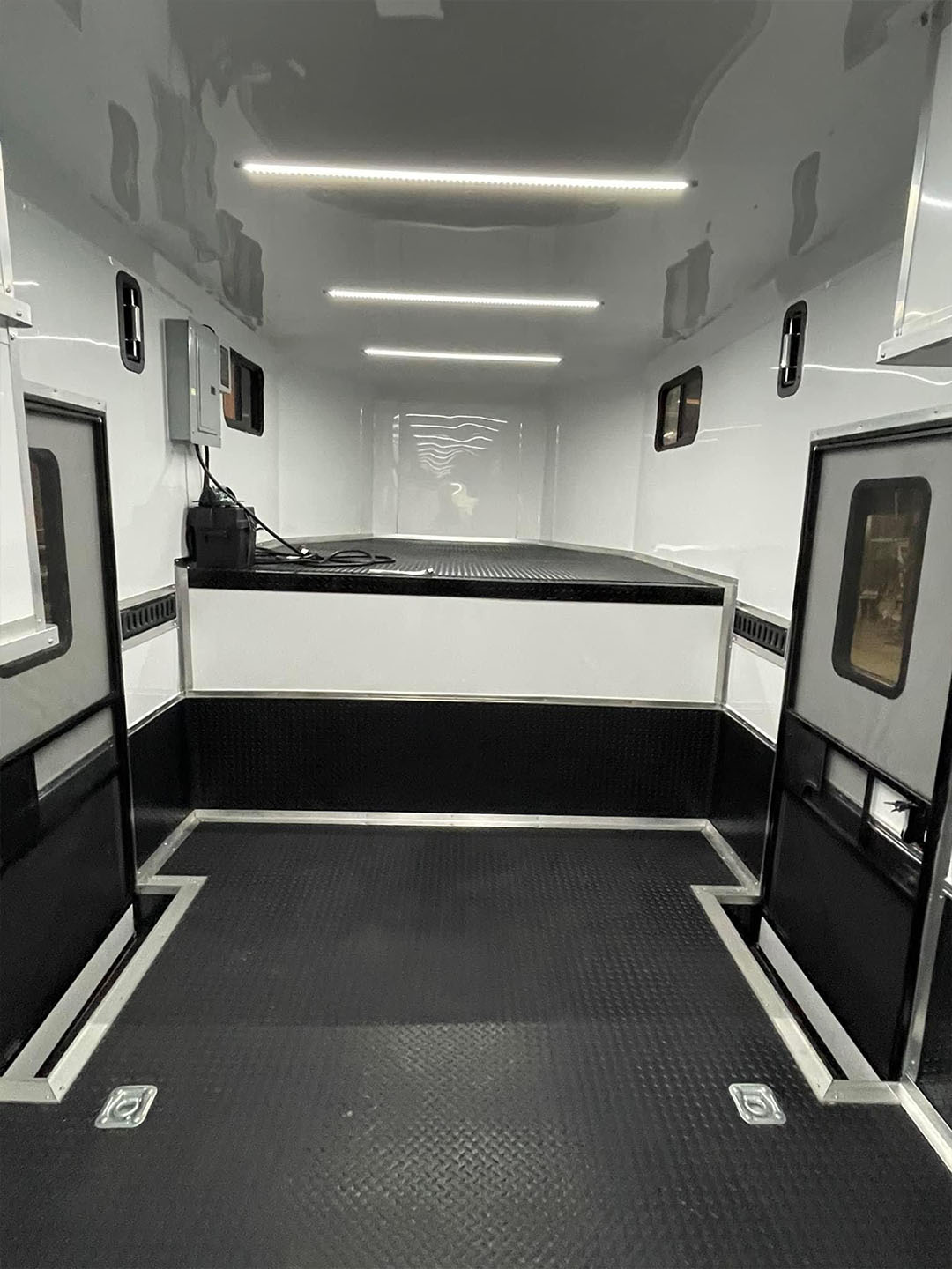 The image shows the interior of an ambulance with medical equipment visible, including a monitor on the wall and a stretcher.