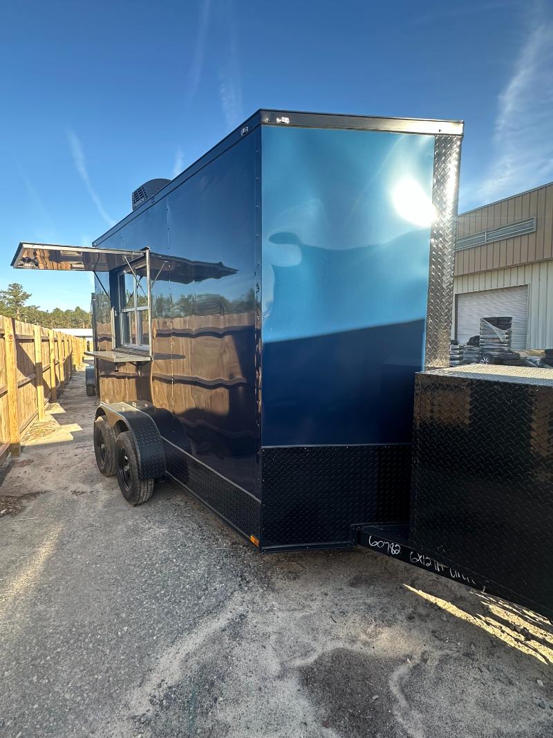 The image shows a large blue food truck parked in an outdoor setting with clear skies above.