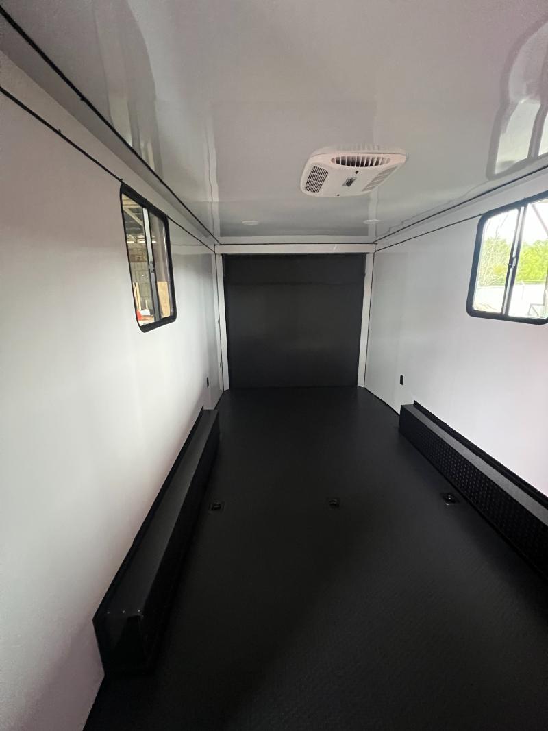 The image shows an interior view of a commercial vehicle, specifically a van, with a focus on its empty cargo area, featuring black flooring and a dark-colored side panel.