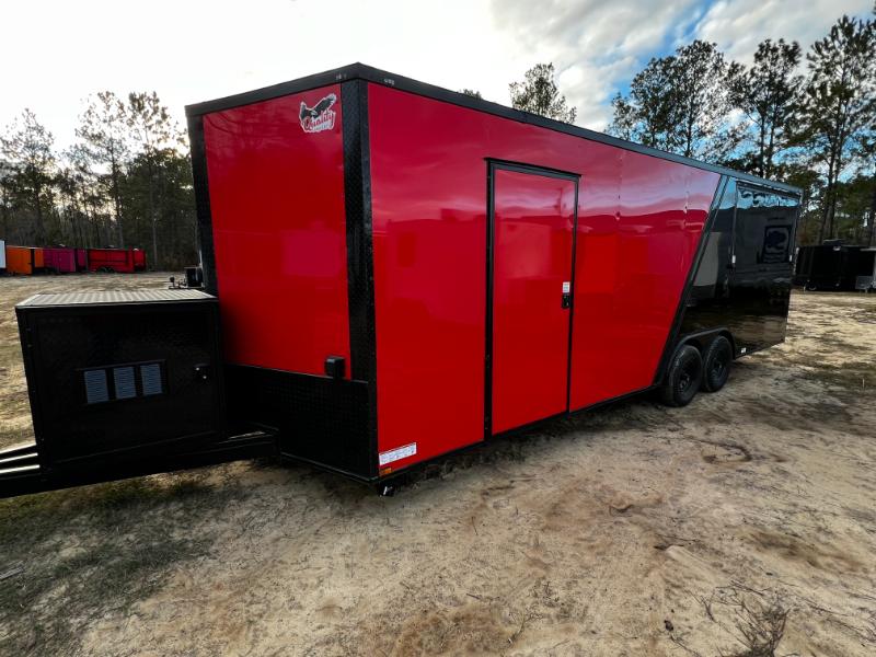 The image shows a large red portable building with a black trailer attached, parked on a dirt surface.