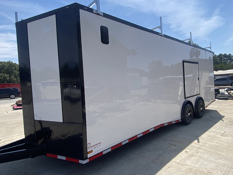 A black and white trailer parked on concrete.